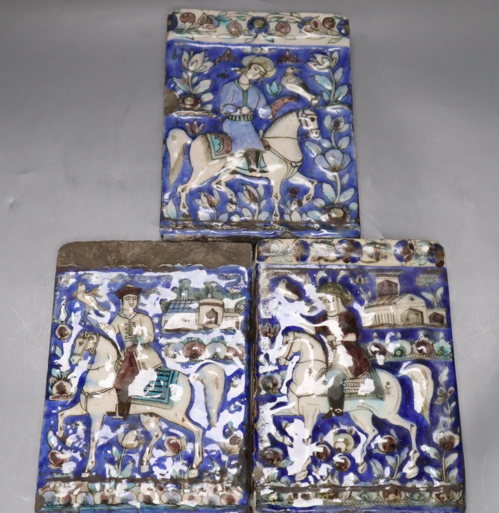 Three Persian pottery wall tiles, Qajar dynasty, relief-moulded with falconers on horseback, each approx 19 x 12.5cm